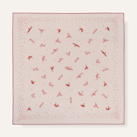 Pink fabric square with red pattern on a white background