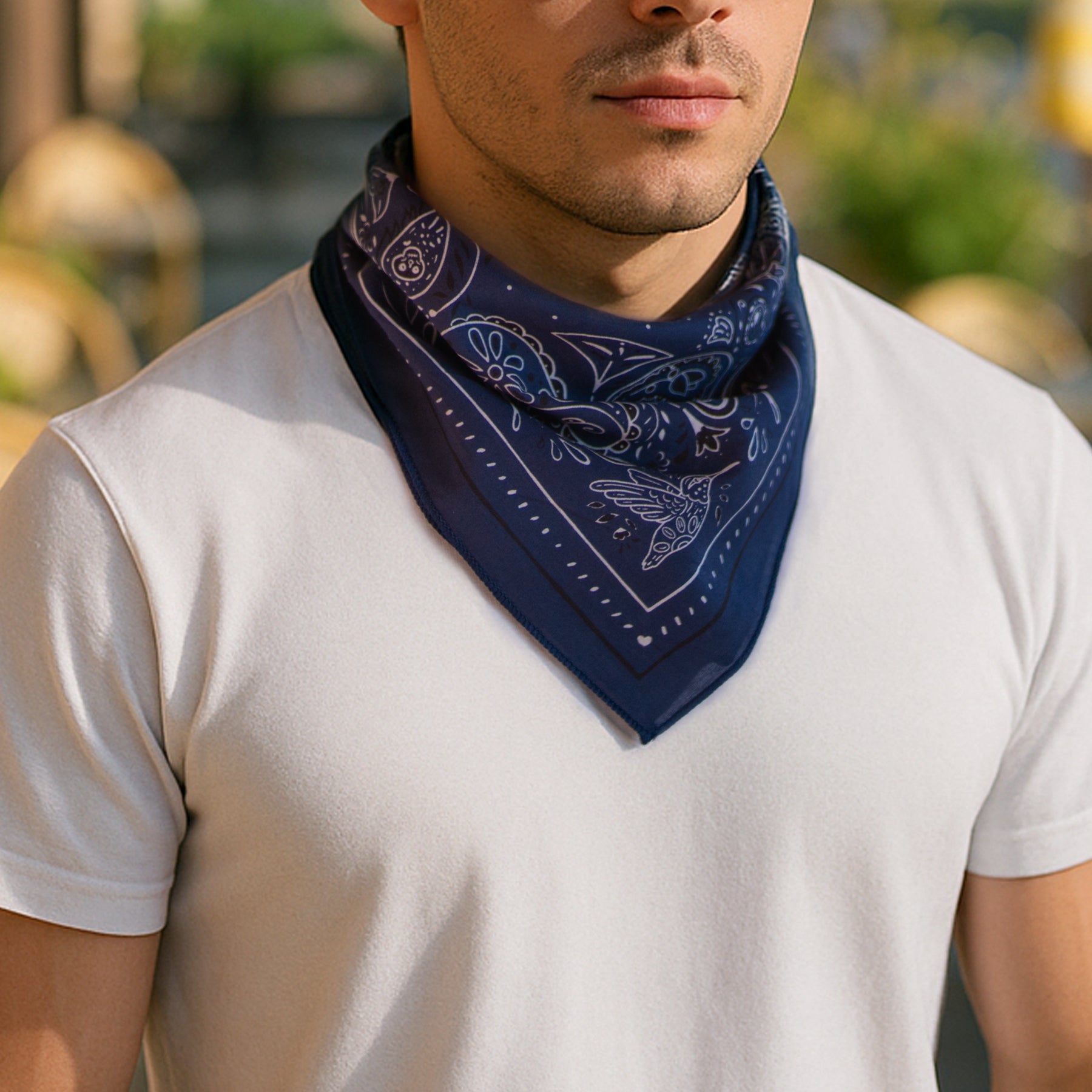Man wearing a navy blue bandana with white patterns on a blurred outdoor background
