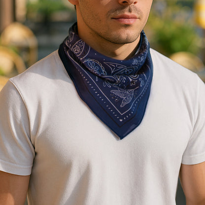 Man wearing a navy blue bandana with white patterns on a blurred outdoor background